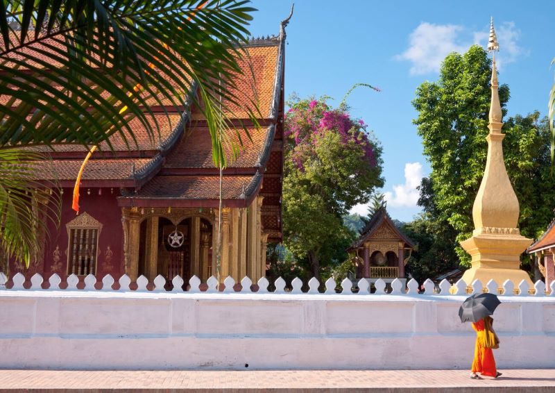 Un moine marche paisiblement devant le temple Way Zen à Luang Prabang