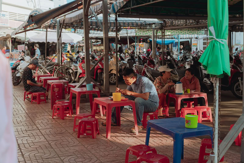 Une rue de restauration installée sur le trottoir, en plein air au marché Binh Tay Saigon