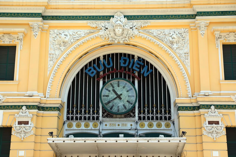 La porte d'entrée principale du bâtiment présente une voûte caractéristique, surmontée d'une grande horloge au centre.