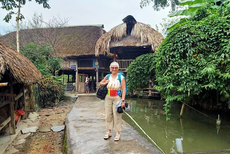 Mme Madeleine Chenette devant la famille d''acceuil a Ha Giang