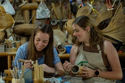 Les visiteurs étrangers sont enthousiastes à l'idée d'expérimenter la fabrication de souvenirs en bambou 