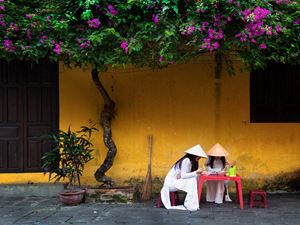 Deux étudiantes en robe traditionnelle au restaurant de rue à Hoi An  9