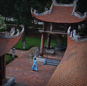 Une dame en robe traditionnelle au temple de littérature à Hanoi 