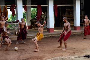 Jeune moine joue au football